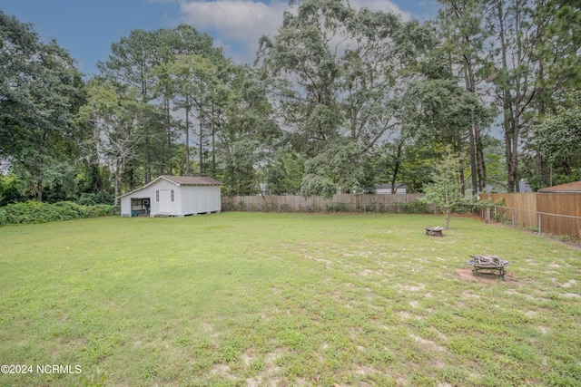 view of yard with a shed and an outdoor fire pit