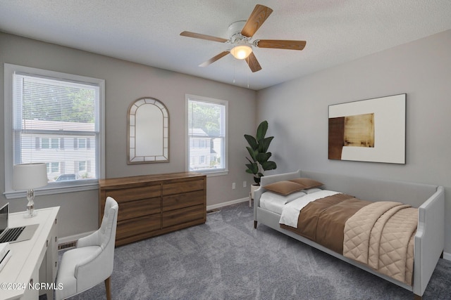 carpeted bedroom featuring multiple windows, ceiling fan, and a textured ceiling