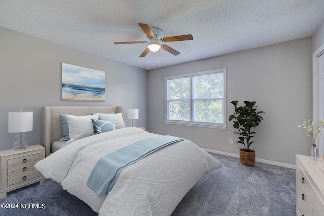 carpeted bedroom with ceiling fan and a textured ceiling