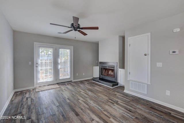 unfurnished living room with ceiling fan and dark wood-type flooring