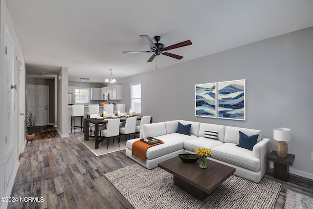 living room featuring hardwood / wood-style flooring and ceiling fan with notable chandelier