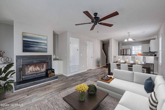 living room featuring hardwood / wood-style floors and ceiling fan with notable chandelier