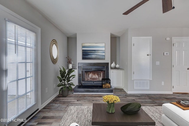 living room featuring ceiling fan and dark wood-type flooring