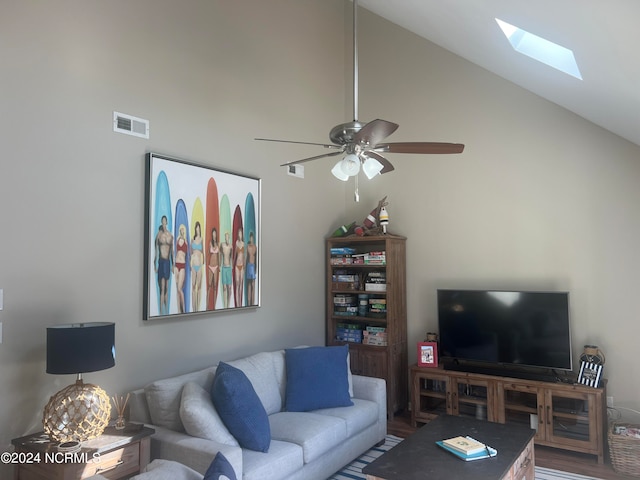 living room featuring ceiling fan, a skylight, and high vaulted ceiling