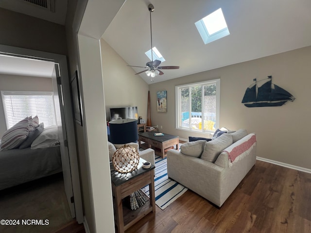 living room featuring vaulted ceiling with skylight, ceiling fan, and dark hardwood / wood-style flooring