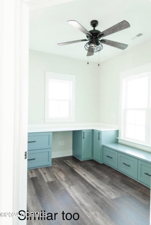 unfurnished office featuring built in study area, ceiling fan, visible vents, and wood finished floors