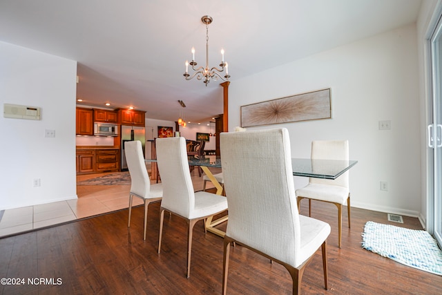 dining area featuring light wood-type flooring and a chandelier