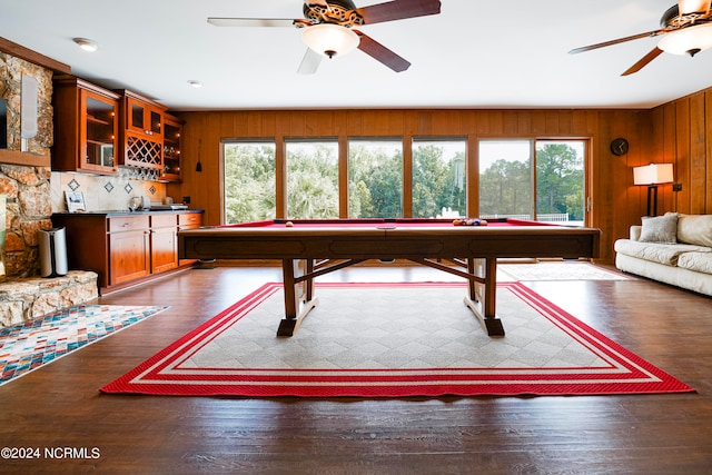 game room with ceiling fan, wood walls, wood finished floors, wet bar, and billiards