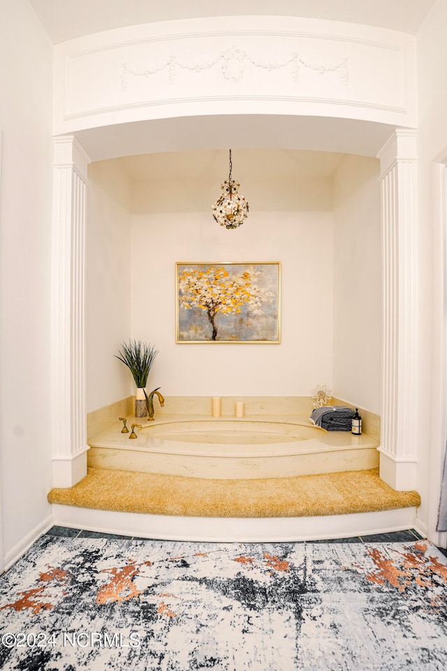 bathroom featuring decorative columns, baseboards, and a bath