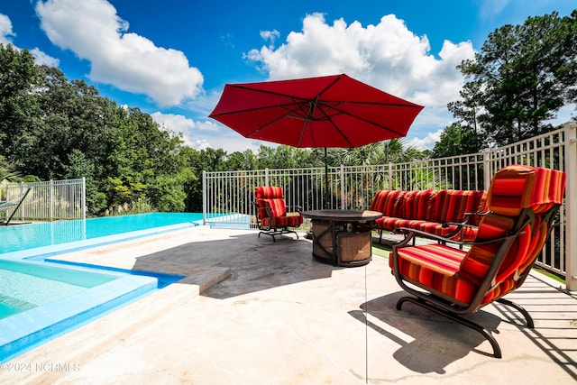 view of pool with a patio and a fire pit