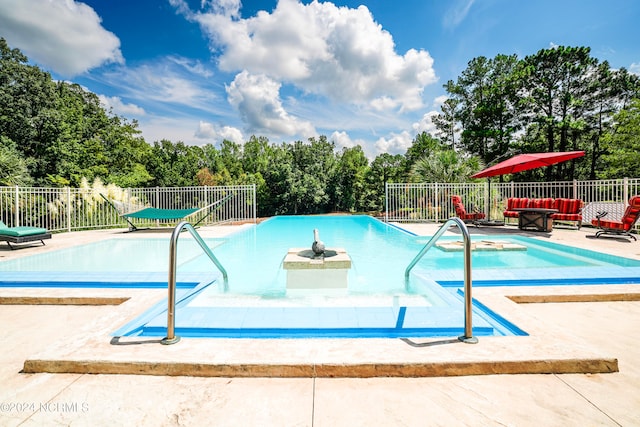 community pool with fence and a patio