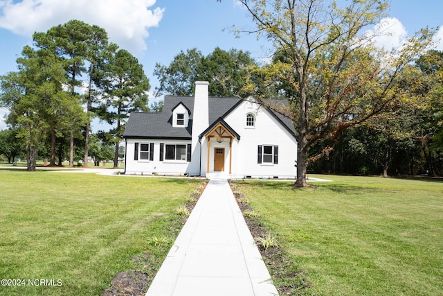 view of front of property featuring a chimney and a front lawn