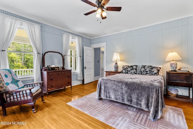 bedroom featuring multiple windows, ornamental molding, and wood finished floors