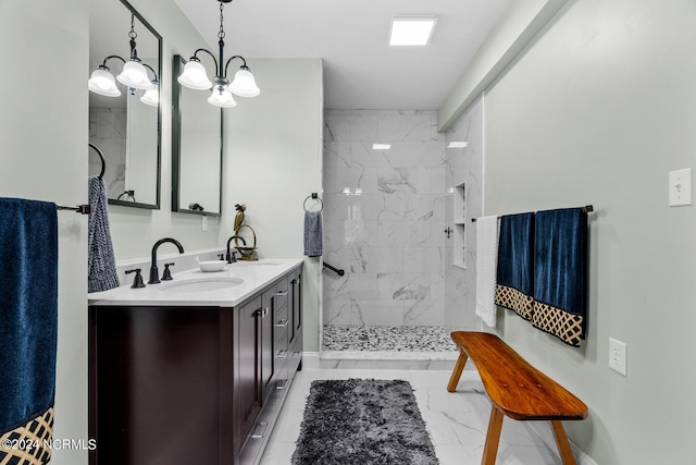 full bathroom featuring double vanity, marble finish floor, a tile shower, and a sink