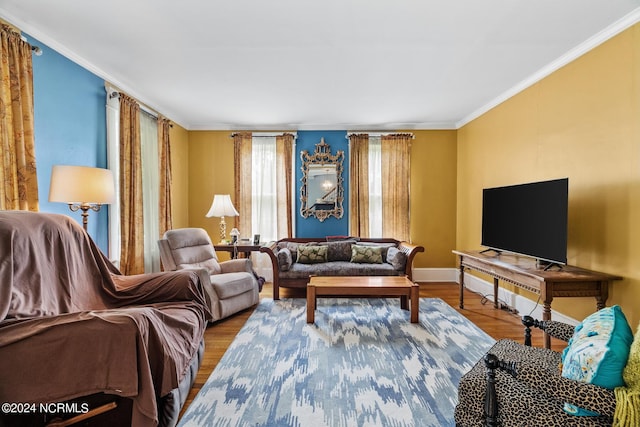 living area with baseboards, ornamental molding, and wood finished floors