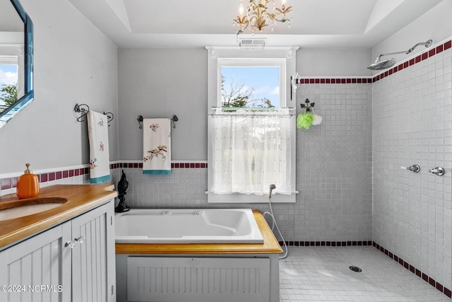 bathroom featuring visible vents, a tile shower, vanity, and a garden tub