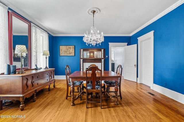 dining space with a chandelier, wood finished floors, and crown molding