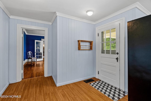 doorway to outside with ornamental molding and wood finished floors