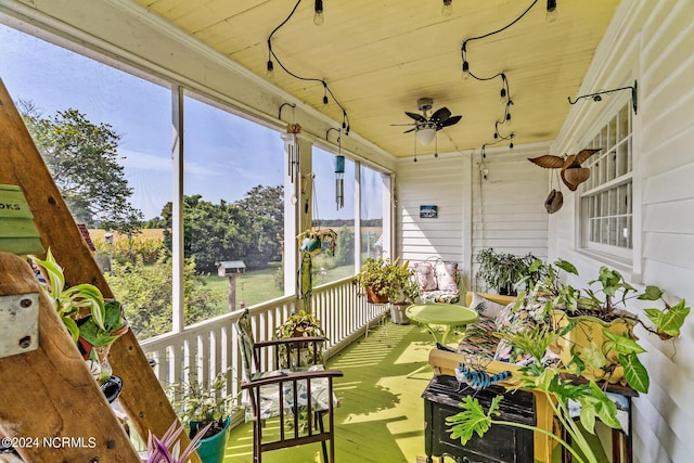 unfurnished sunroom featuring wood ceiling and a ceiling fan