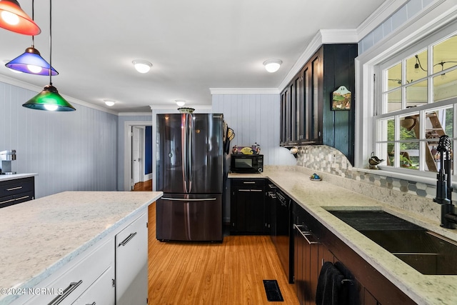 kitchen featuring visible vents, light wood-style flooring, ornamental molding, black appliances, and a sink