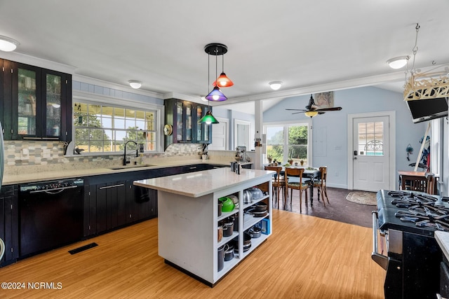 kitchen featuring dishwasher, backsplash, a sink, and lofted ceiling