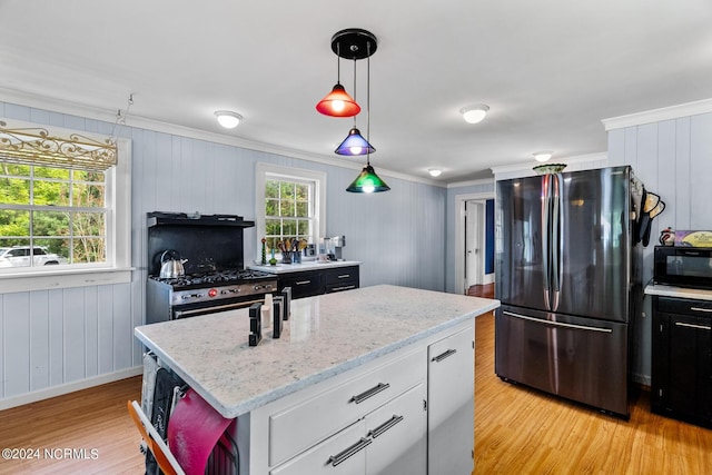 kitchen with light wood-style floors, crown molding, stainless steel appliances, and a wealth of natural light