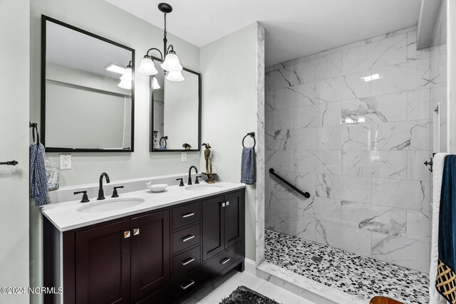 bathroom featuring vanity, a chandelier, and a tile shower