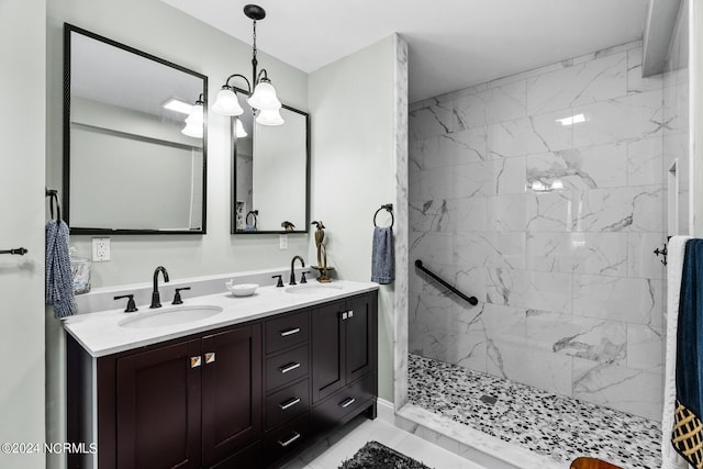 bathroom with double vanity, a marble finish shower, and a sink