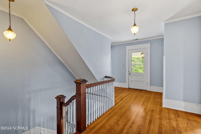 entrance foyer with crown molding, wood finished floors, visible vents, and baseboards