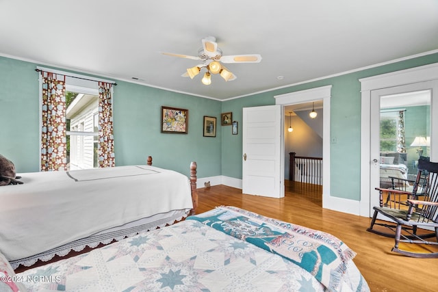 bedroom featuring multiple windows, crown molding, baseboards, and wood finished floors