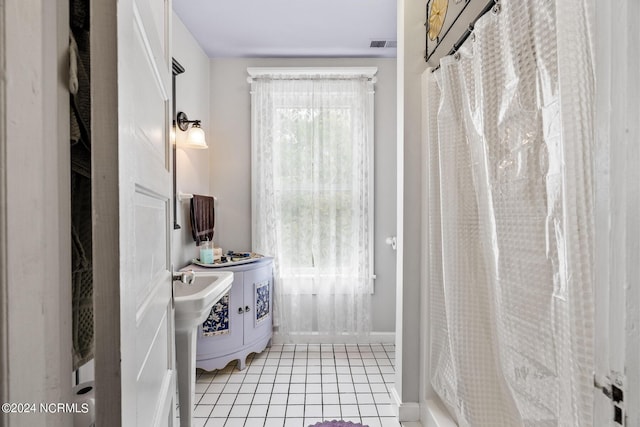 full bath with a shower with shower curtain, tile patterned flooring, visible vents, and baseboards