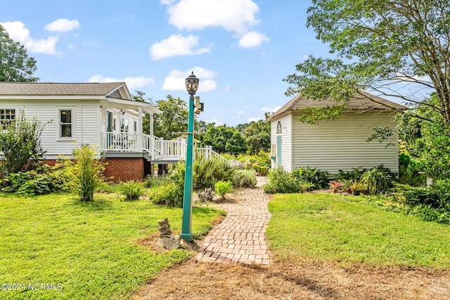 view of yard featuring covered porch and stairs