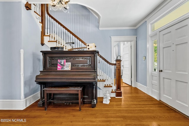 entryway featuring crown molding, stairs, baseboards, and wood finished floors