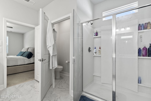 bathroom featuring toilet and a shower with shower door