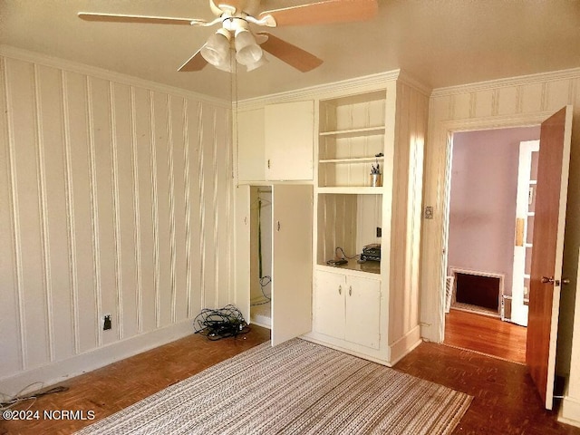 spare room with ceiling fan, built in shelves, and crown molding