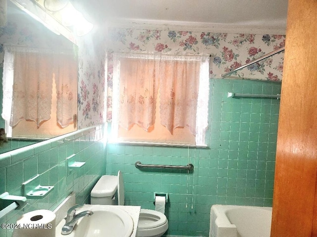 bathroom featuring a wainscoted wall, a sink, toilet, and wallpapered walls