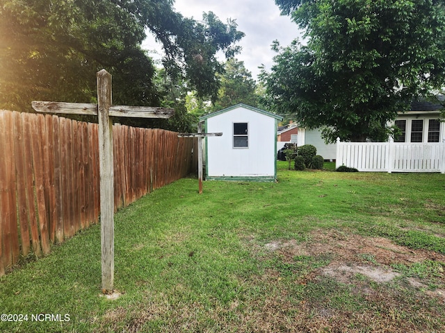 view of yard with fence private yard, an outbuilding, and a storage shed