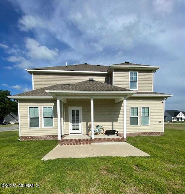 rear view of property with a patio area and a lawn