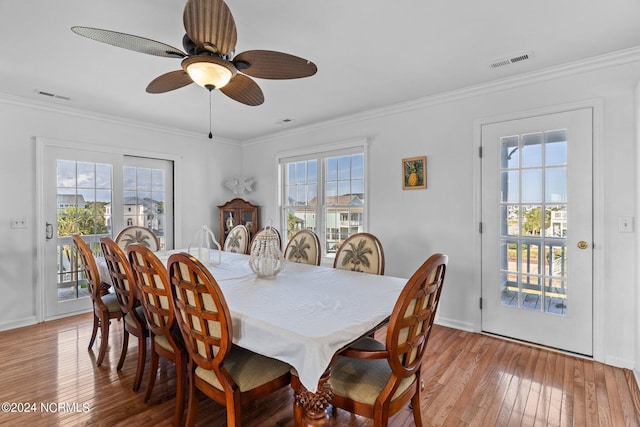 dining space with ornamental molding, light wood-style flooring, and visible vents