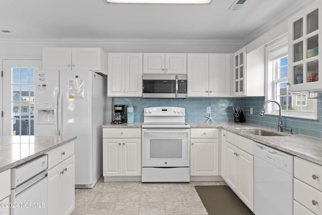 kitchen with white appliances, white cabinetry, a sink, and ornamental molding