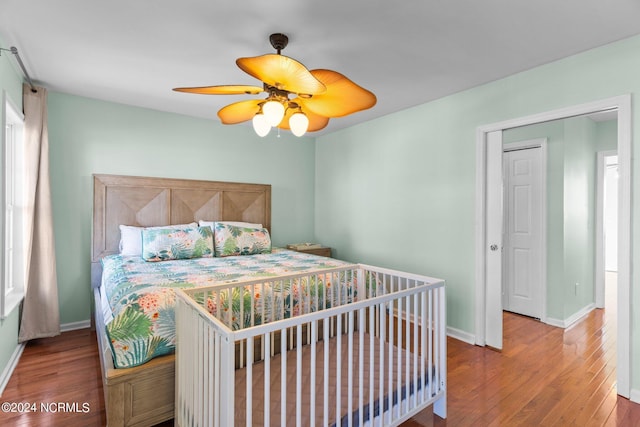 bedroom featuring wood finished floors, a ceiling fan, and baseboards