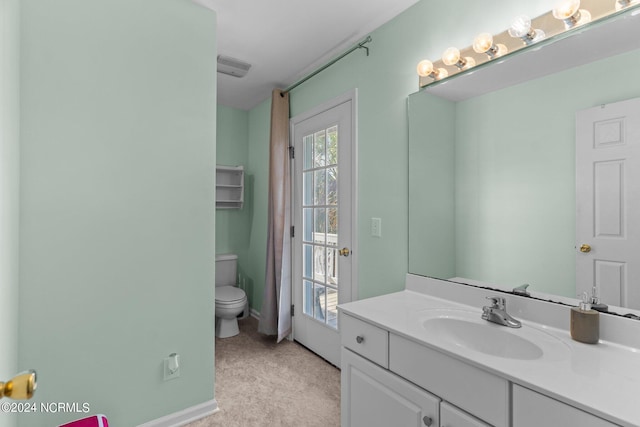 bathroom featuring vanity, toilet, and baseboards