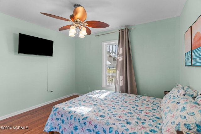 bedroom featuring ceiling fan, wood finished floors, and baseboards