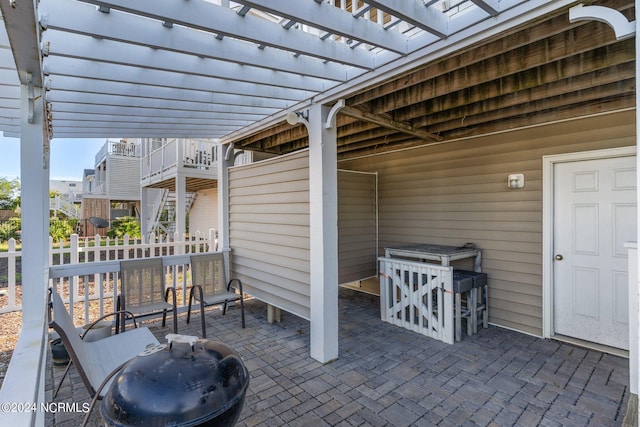 view of patio featuring fence, stairway, and a pergola