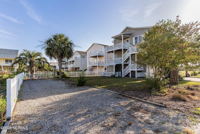 view of property with gravel driveway and fence