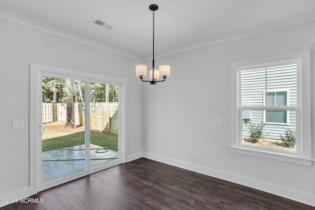 interior space featuring dark wood-type flooring, plenty of natural light, a notable chandelier, and ornamental molding