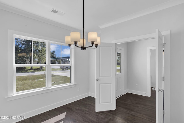 unfurnished dining area featuring crown molding, dark hardwood / wood-style flooring, and a notable chandelier