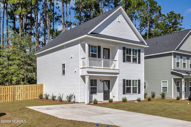 view of front facade with a balcony and a front yard