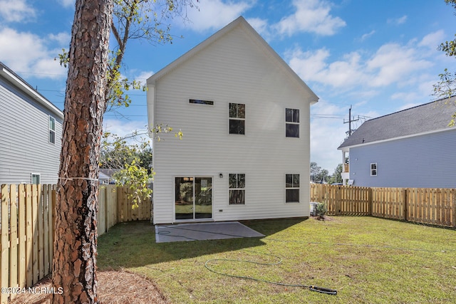 rear view of property with a lawn and a patio