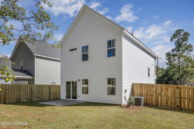 rear view of house with a yard, a patio area, and central AC